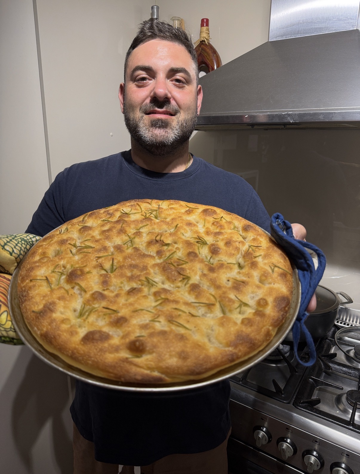 Giuseppe Nasti proudly presenting a freshly baked rosemary focaccia